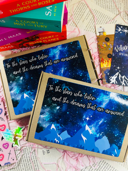 Flat lay of an ACOTAR-themed mystery bookish bundle featuring double-sided bookmarks, holographic stickers, a keyring, art print, annotate tabs, pen and highlighter. Items are displayed with Sarah J. Maas books and pink shredded paper, creating a cosy, fantasy-inspired aesthetic.