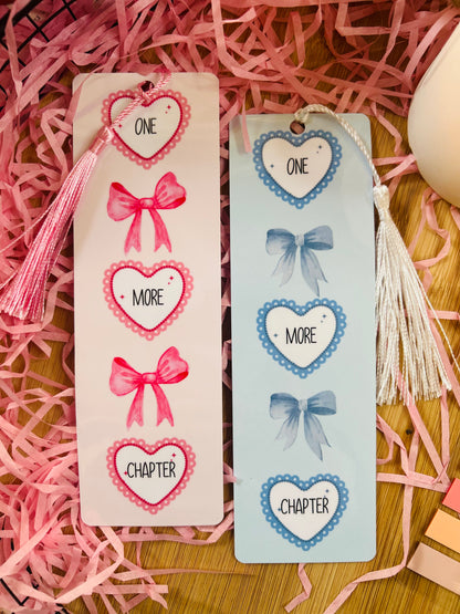 Pink and blue bookmarks with a heart and bow design featuring the quote ' One more chapter'