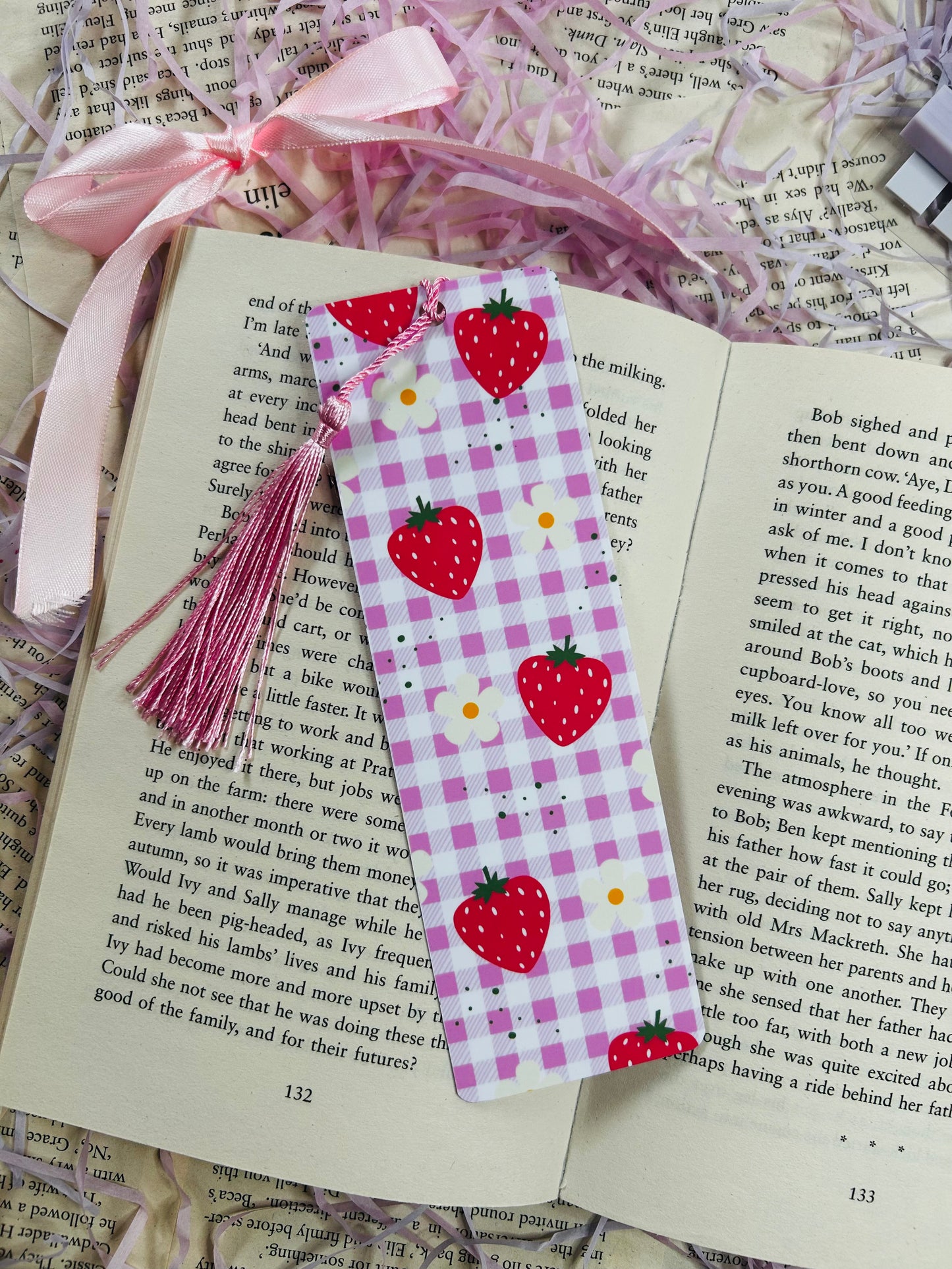 Set of colorful gingham bookmarks with fruit illustrations including cherries, strawberries, and citrus, placed on an open book.