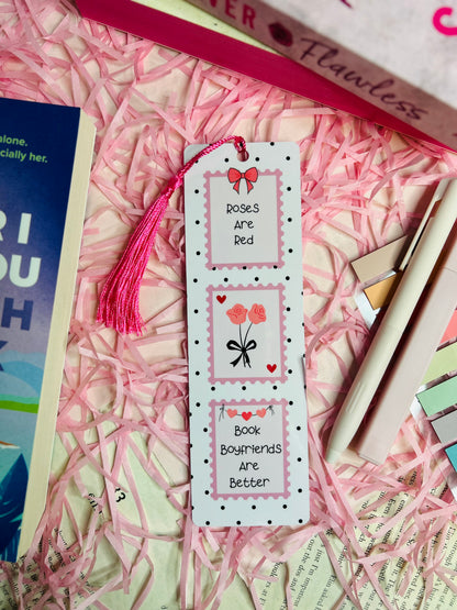 Aesthetic romance-themed bookmark with "Roses Are Red, Book Boyfriends Are Better" quote, featuring a pink tassel, cute heart and rose illustrations, and a polka dot design.