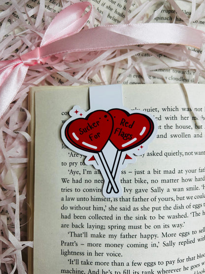 Magnetic bookmark featuring two vibrant red heart-shaped balloons with the playful text 'Sucker for Red Flags.' k