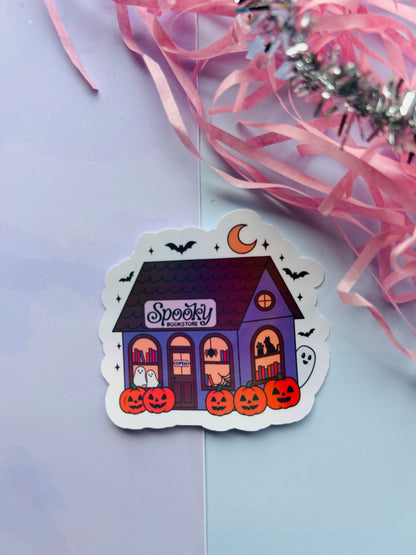 Halloween-themed sticker with a purple house, pumpkins, and 'Spooky' text on a light purple background.