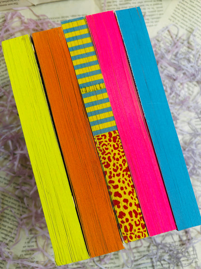 Mystery book bundle for kids with a surprise book, bookmark, bubbles, stickers, and packaging on pink shredded filler.