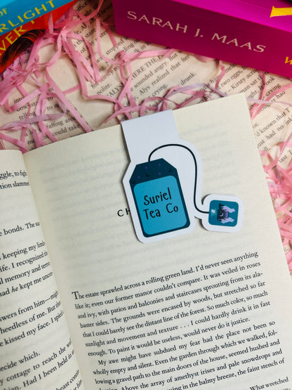 Book with a bookmark featuring 'Suriel Tea Co.' on an open book background