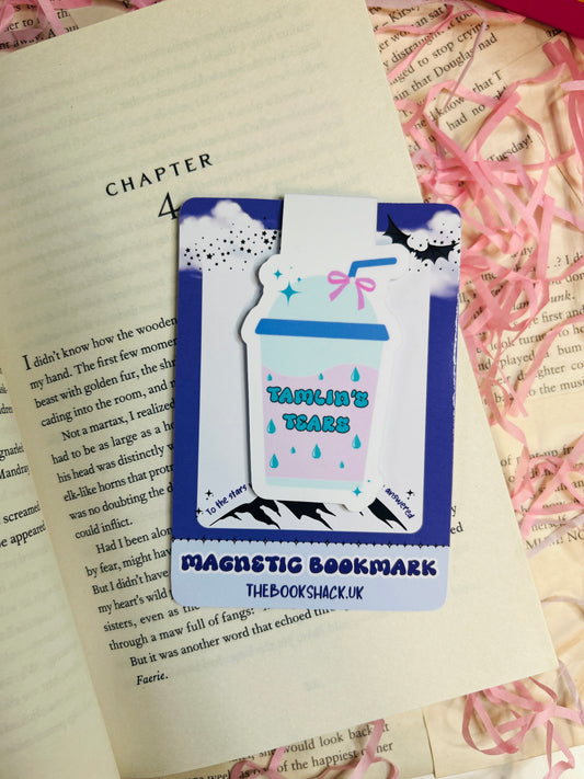 Magnetic bookmark shaped like a takeaway cup labelled “Tamlin’s Tears,” clipped to a fantasy book page with pink shredded paper in the background.