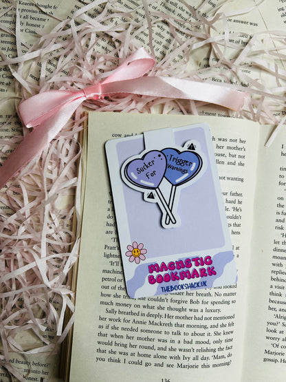 Magnetic bookmark featuring two soft purple heart-shaped balloons inscribed with 'Sucker for Trigger Warnings.'