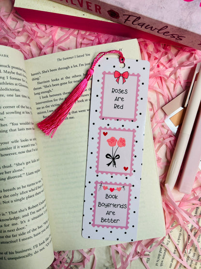 Aesthetic valentine romance-themed bookmark with "Roses Are Red, Book Boyfriends Are Better" quote, featuring a pink tassel, cute heart and rose illustrations, and a polka dot design.